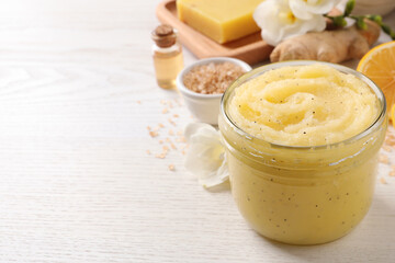 Body scrub in glass jar on white wooden table, closeup. Space for text