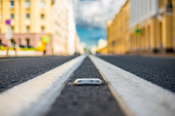Clear day in the big city, empty city street under sunlight. View of the road at the level of the dividing line