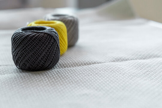 Sewing threads for home crafts of gray and yellow trend colors on linen cloth for embroidery background