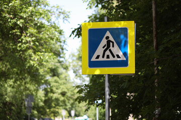 Pedestrian crossing road sign on yellow background