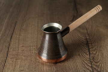 Copper turkish coffee pot on wooden table