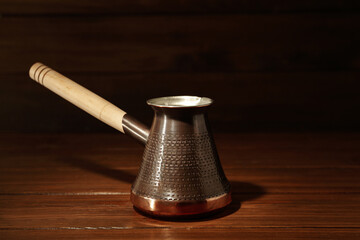 Beautiful copper turkish coffee pot on wooden table