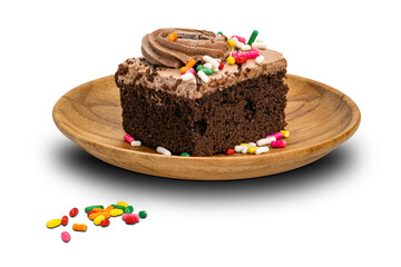 Rainbow sprinkles topping on cream chocolate sponge cake in wooden plate isolated on white background with clipping path.