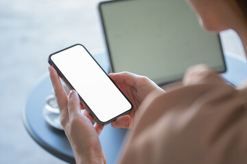 Close-up view of businesswoman searching for important information on a smartphone for her current project.