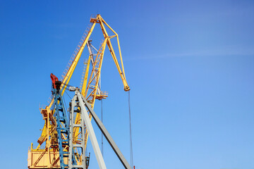 Yellow construction crane on blue sky background