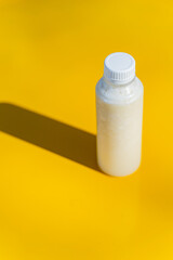 The juice bottle with its shadow on the yellow surface