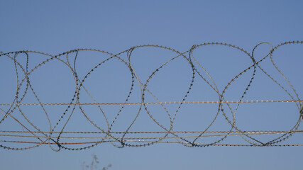 Barbed wire fence against the blue sky in India