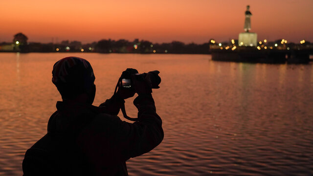 Silhouette of a photographer capturing the sunset in India, travel photographer shooting the beautiful landscape