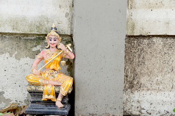 Thai angel statue located on the road beside the white wall at Thailand.