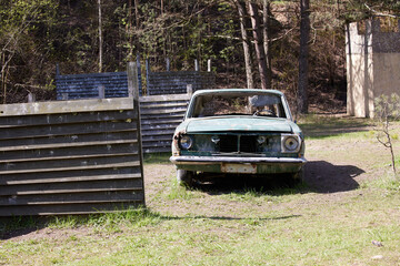 Photo scrap metal, rusty car in the forest