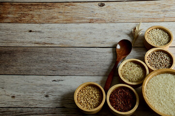 Brown Glutinious Rice, Red Jasmine Rice, Oat Rice, Barley, Millet Rice, Brown Wheat in wooden bowl and wooden spoon on wooden table background.