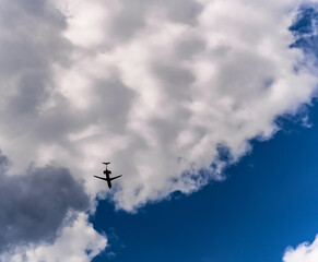 Fototapeta na wymiar Silhouette of aeroplane over clouds and blue sky