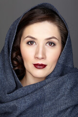 Beauty portrait of brunette woman dressed in dark blue scarf.