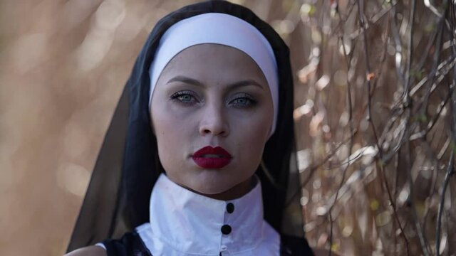 sexy woman with red lips is wearing nun clothes, portrait at nature, depraved righteous woman
