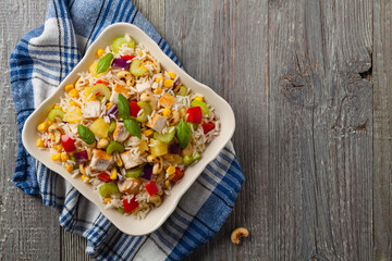Salad with rice, chicken, peanuts and vegetables. Top view.