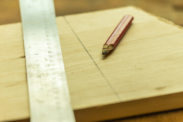 craftsman pencil on a plank to mark a measured line