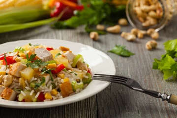Salad with rice, chicken, peanuts and vegetables. Front view.