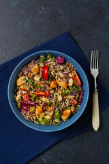 Salad with quinoa, avocado and chicken. Top view. Served in a blue bowl.