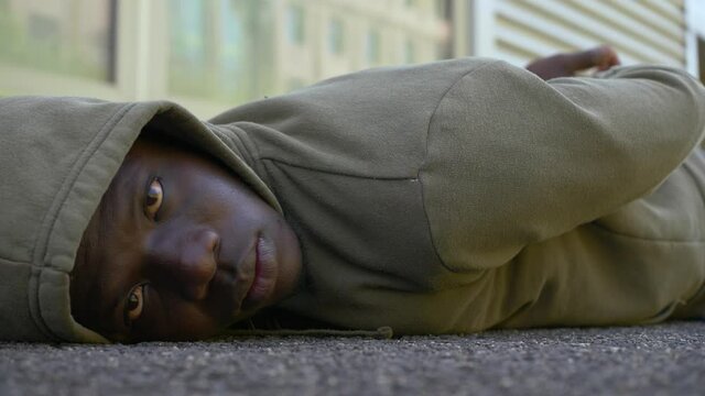 protest symbol - black man lying on the ground stares at camera