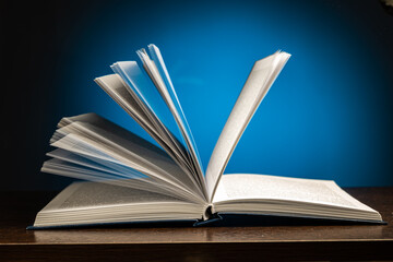 flipping through the pages of an open book on a blue background