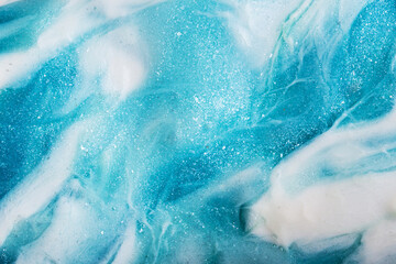 Liquid art gel blue gradient background with glitter. Slime toy. Abstract blue white surface. 