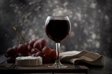 The still life with red wine, vine, cheese.