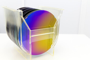 Silicon Wafers in plastic storage box in clear room of semiconductor foundry.