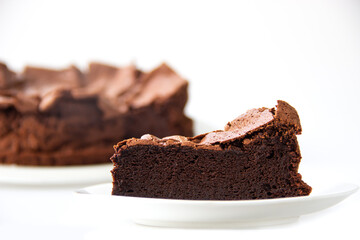 Slice homemade flourless chocolate cake on white background. Free gluten dessert. Crunch top of cake and soft with moist with texture.