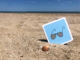 Concepto gafas de sol verano en arena de playa con textura y mar de fondo. Tienda gafas de sol verano vacaciones