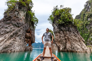 Happy Young Tourist Man at Longtail Boat near Famous Three rocks with Limestone Cliffs at Cheow Lan...