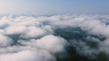 View from the airplane window to the clouds from above.