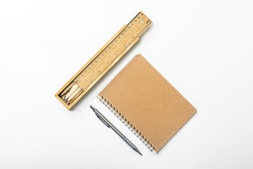 Brown pen and notebook and pencil case and wooden pencils on the desk.