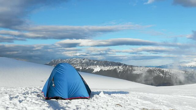 A blue tent on the Iezer Mountain Range covered in the snow in Romania shot in HD