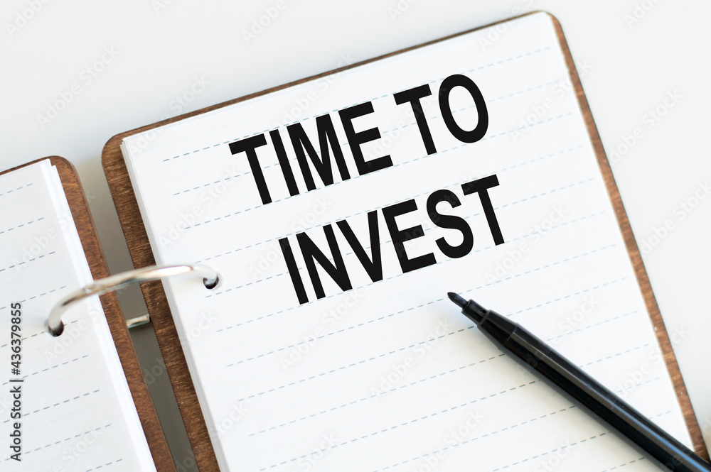 Poster notepad page with the text time to invest. view from above. business concept.