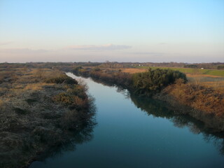 夕暮れ時、晩秋の川と岸辺