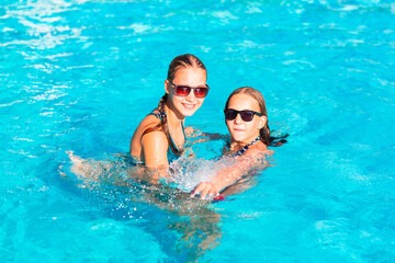 Happy beautiful girls having fun at the pool