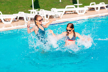 Happy beautiful girls having fun at the pool