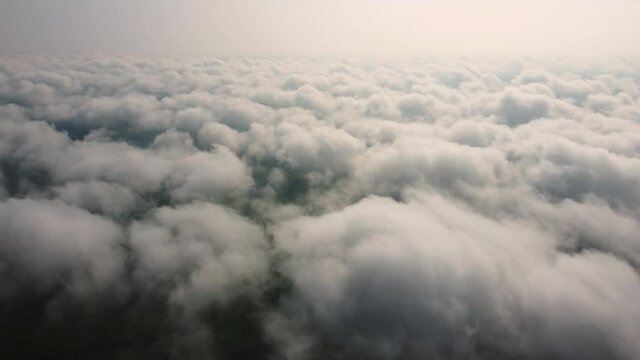 View from the airplane window to the clouds from above.