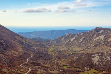  Balkan road trip. Beautiful mountain landscape. Mountain range of Dinaric Alps in early spring. Adriatic Sea in distance. Bosnia and Herzegovina, Republika Srpska