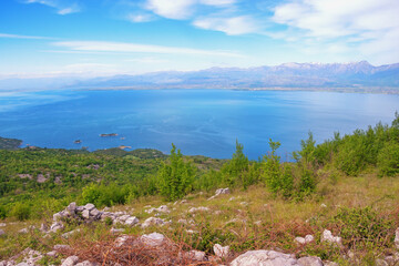 Beautiful blue lake surrounded by mountains on sunny spring day. Skadar Lake National Park, Montenegro