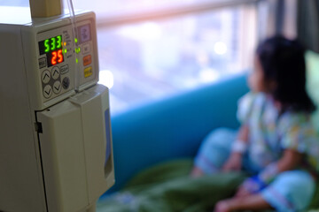 Vital sign monitor with background of blurry Asian kid patient sitting closed to the window