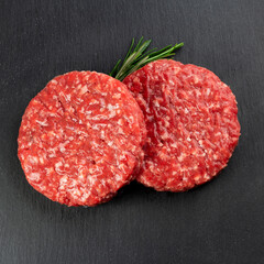 Hamburger meat with rosemary and black background