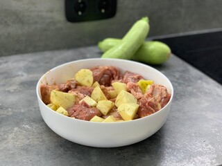Potatoes with meat prepared for stewing.