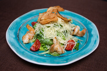 Greek salad with chicken breadcrumbs on a plate in a cafe.