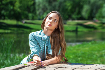 Portrait of a teenage girl on the background of a summer park