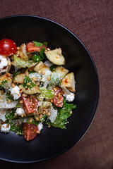 salad with eggplant in sour sweet sauce in a black plate.