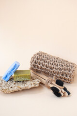 Fototapeta na wymiar Zero waste bathroom accessories - toothbrushes, natural soap and knit twine scrubber on a beige background. Sustainable lifestyle concept.
