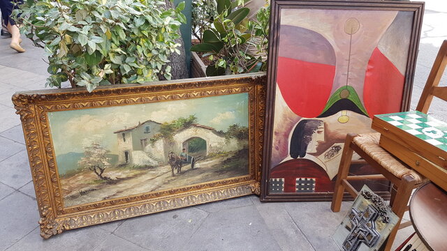 Old oil paintings in ornate picture frames and antique stuff at flea market on street in Athens, Greece, 06 06 2018