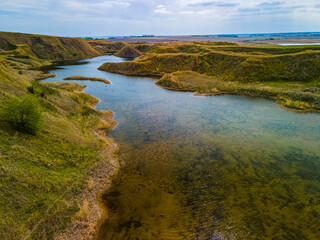 An aerial view of a tranquil pond found in a hidden valley in the vast Saskatchewan prairies