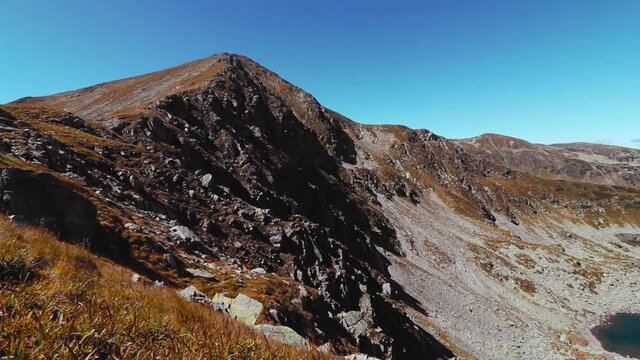 A landscape of the Parang Mountains under the sunlight and a blue sky in Romania shot in HD
